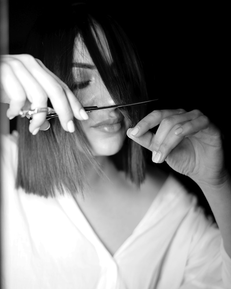 Hair stylist che rifinisce un taglio bob con forbici e pettine