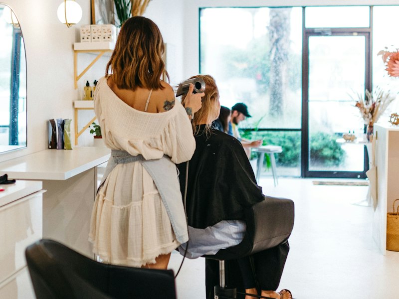 Hair stylist al lavoro in un salone luminoso