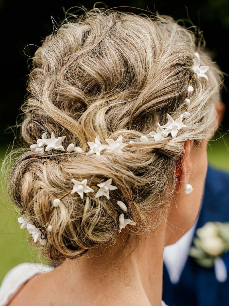 Raccolto sposa morbido con fiori tra i capelli